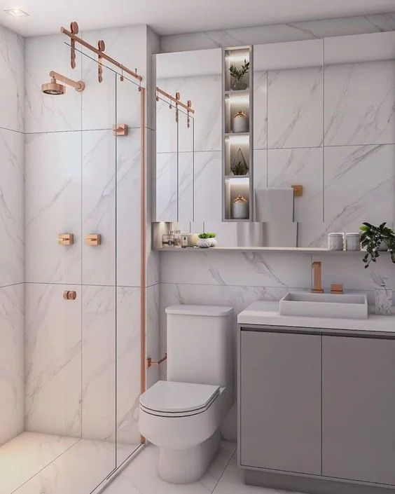 Banheiro pequeno com nicho embutido no box, iluminado com fita de LED.