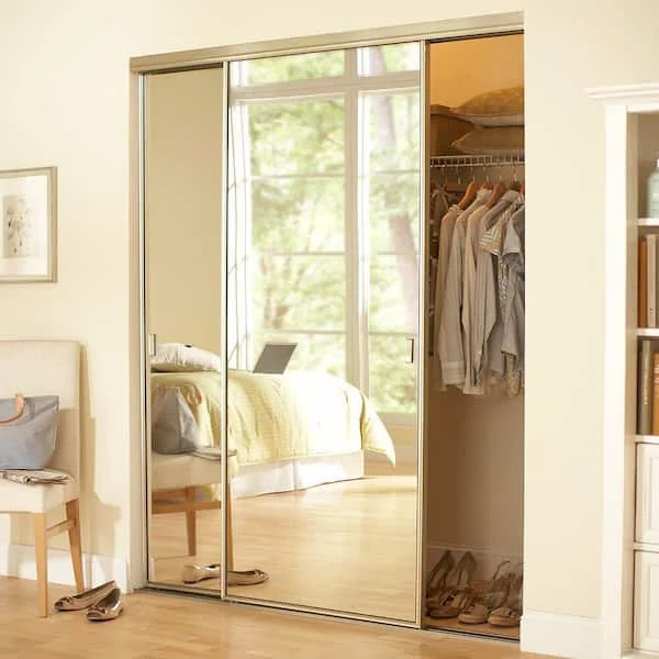 Closet pequeno e funcional em um nicho do quarto, com portas de espelho de correr.