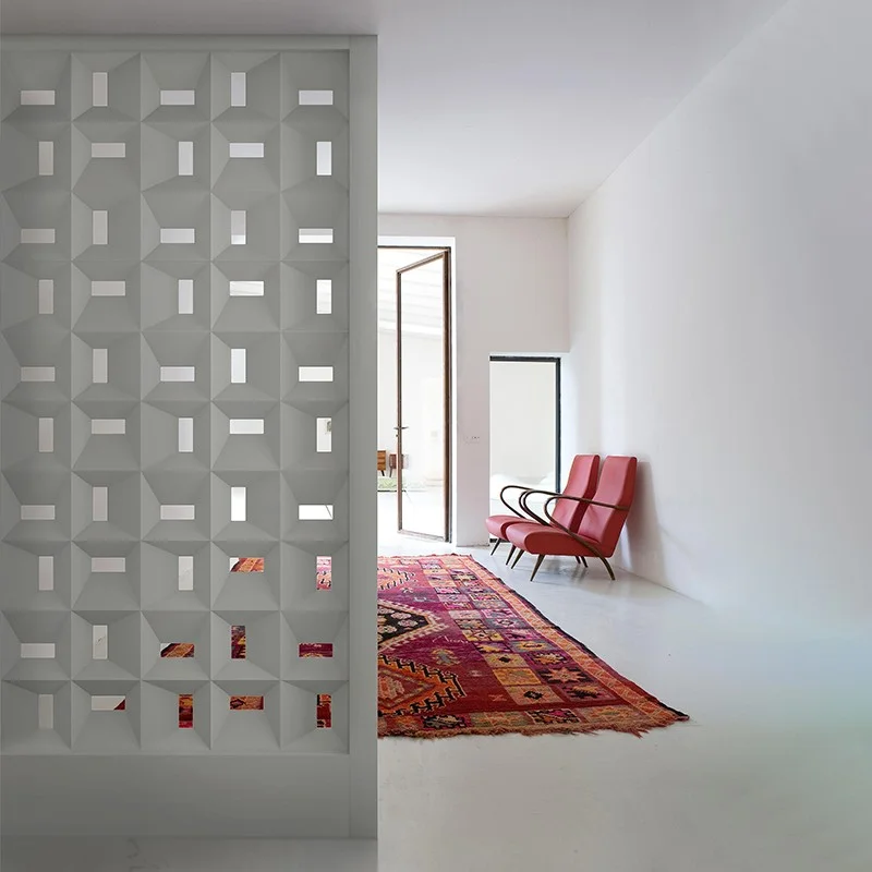 Divisória de cobogós de cerâmica esmaltada azul separando uma cozinha de uma sala de jantar.