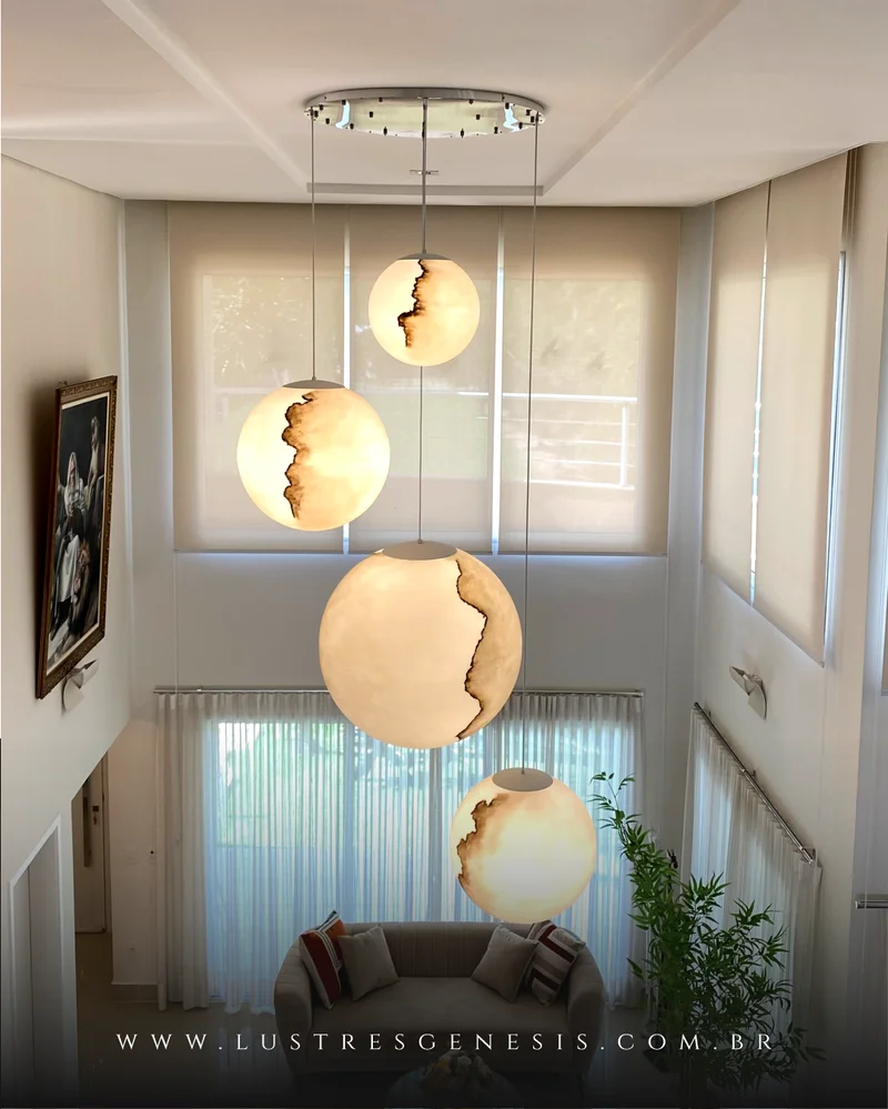 Sala de jantar com um grande lustre pendente em um ambiente com pé-direito duplo.