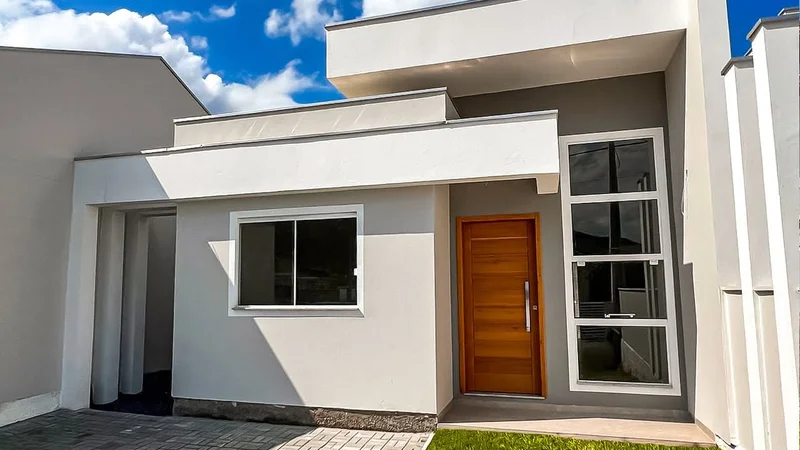 Fachada de uma casa com platibanda que combina diferentes materiais como madeira, vidro e concreto.
